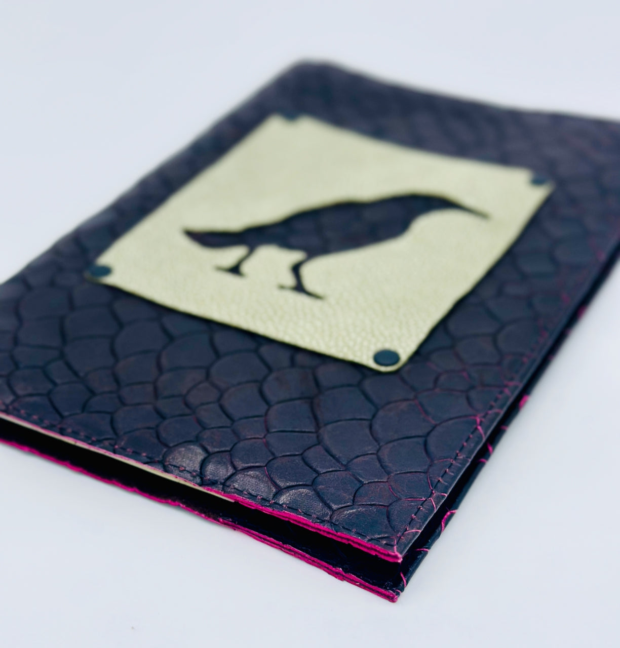Black dragon scale textured leather refillable journal with a green leather patch featuring a bird design on a white background