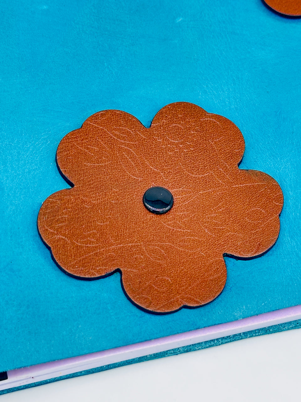 close-up- of an embossed brown leather on a Journal-with-bead-tassel-
