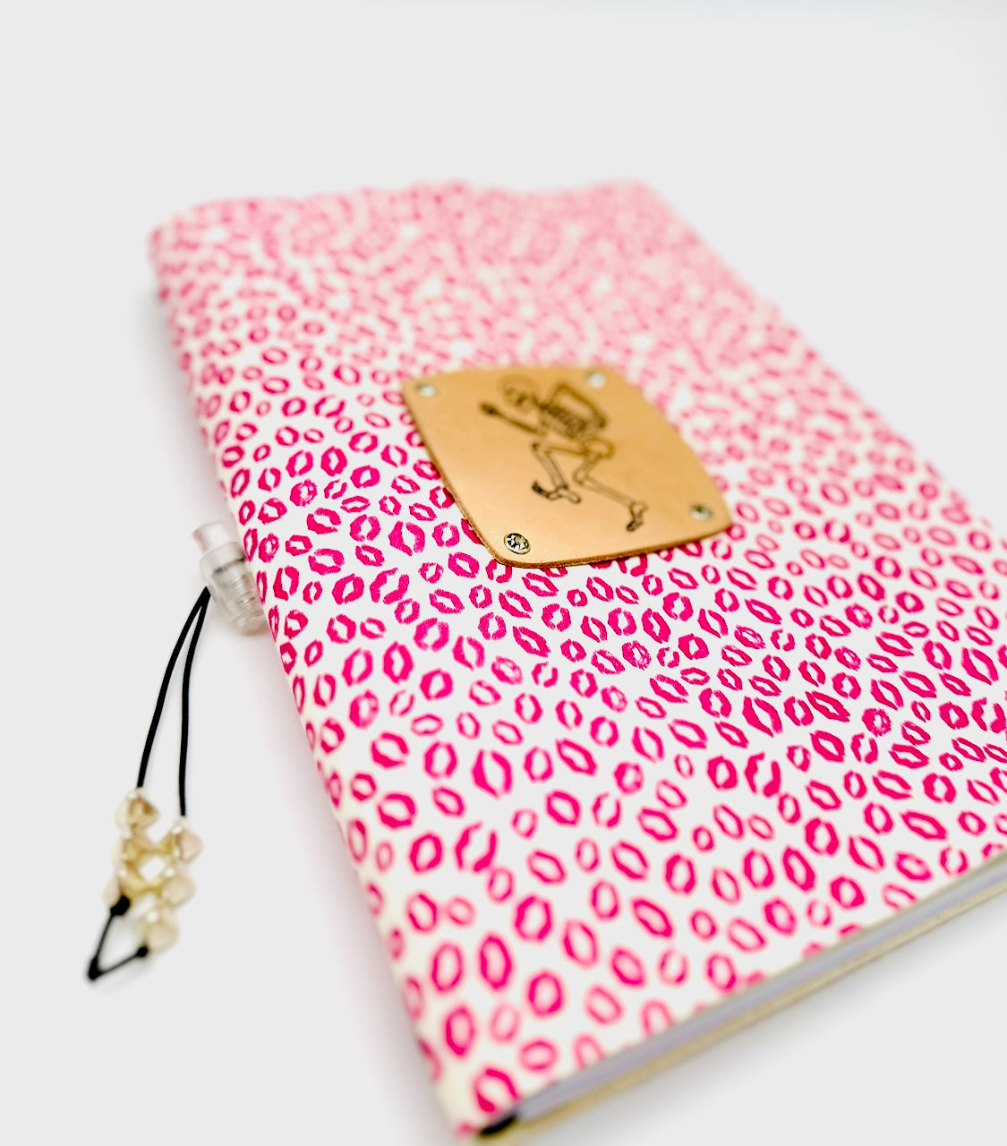 soft focus of leather journal cover with dancing skeleton and lipstick kisses