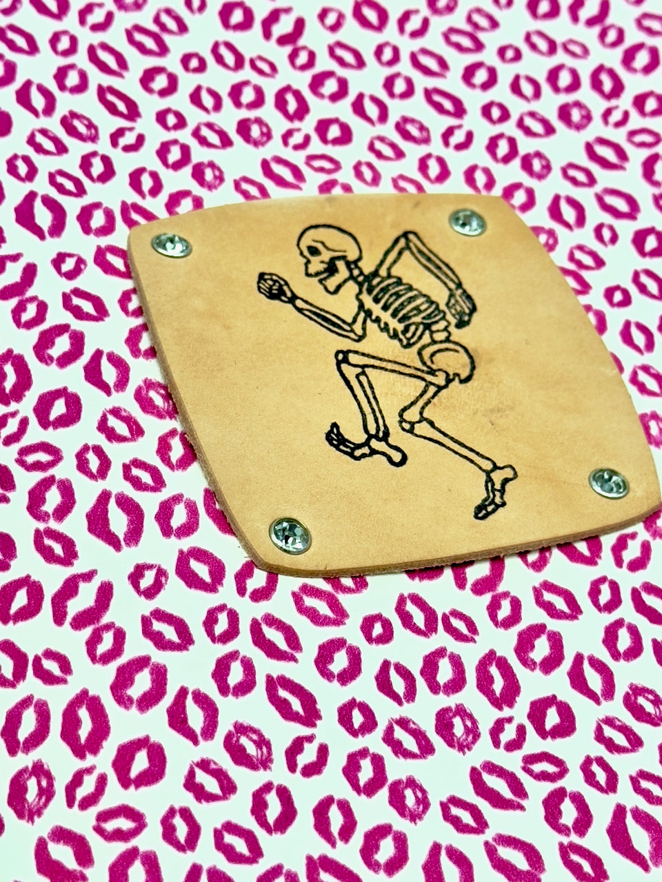 detail of stamped dancing skeleton on leather journal cover
