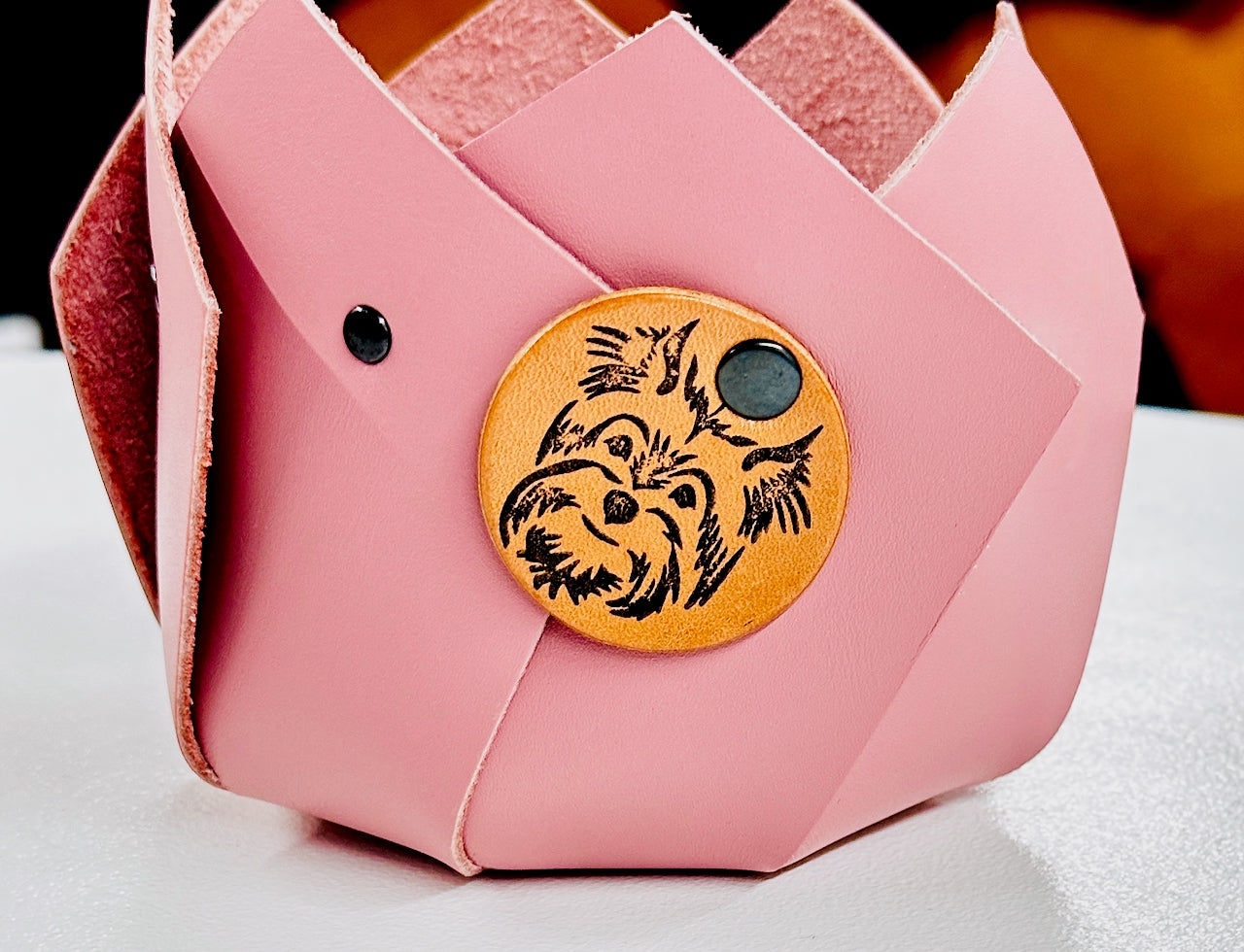 Pink pleated leather geometric plant container with a leather patch featuring a dog design.