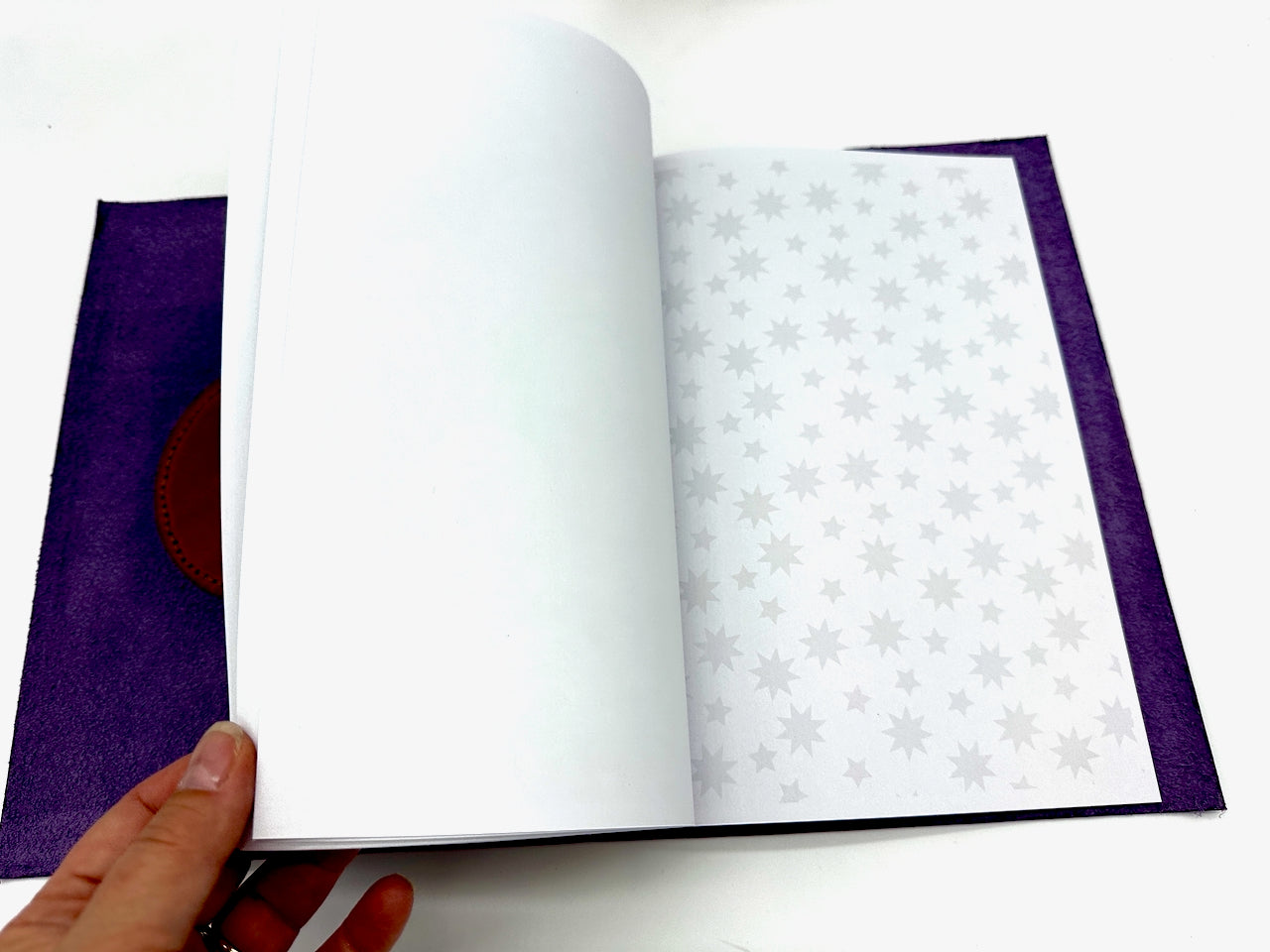 Inside leather journal journal showing paper notebook insert with stars.