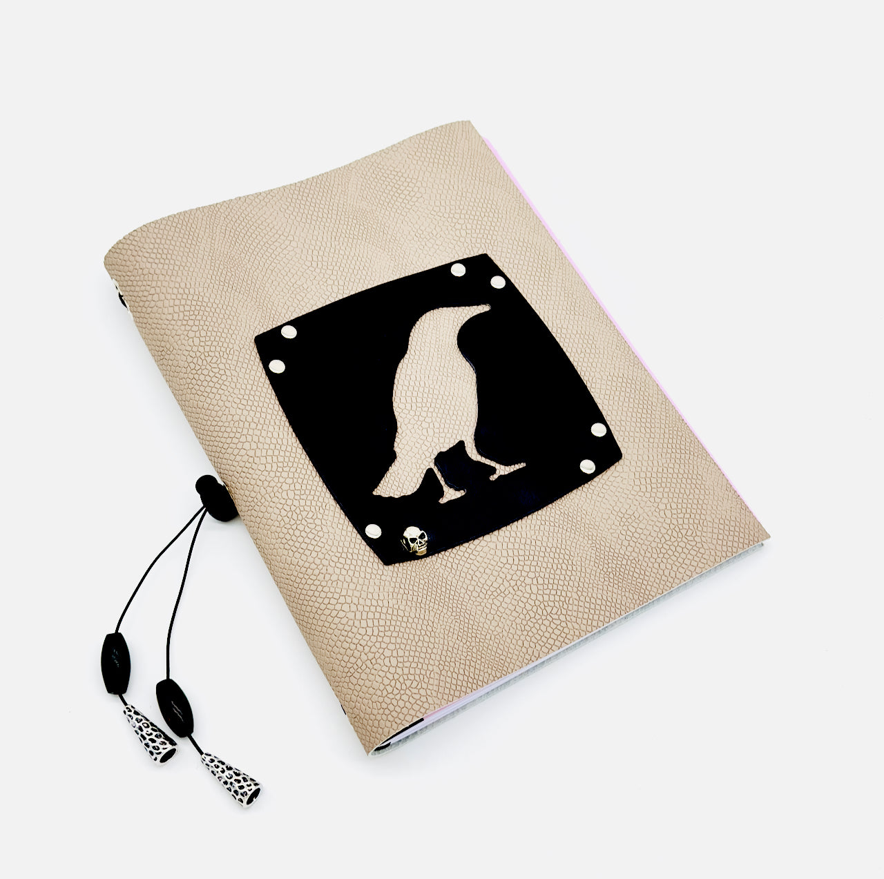 wide shot of leather journal featuring a black bird cut out on front cover