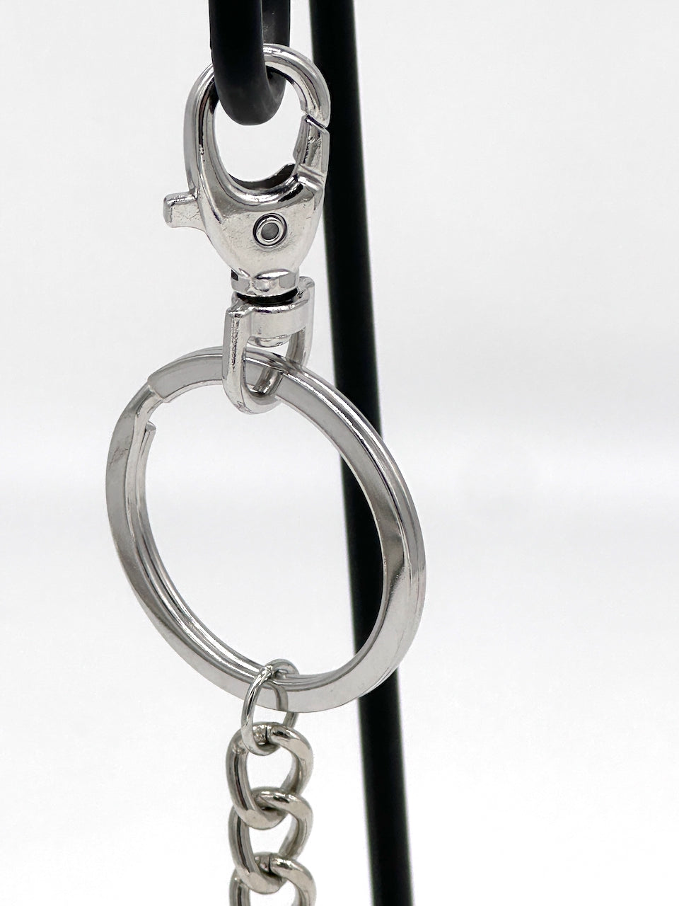 closeup of silver key chain and lobster clasp hardware from a leather key chain purse fob