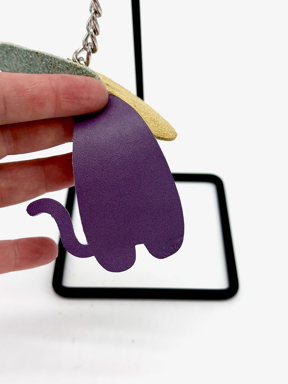 detail features purple body of cat with tail on cat leather key chain purse fob