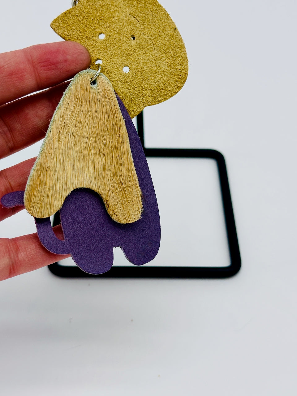 detail of hair on hide leather on three part leather cat key chain and purse fob