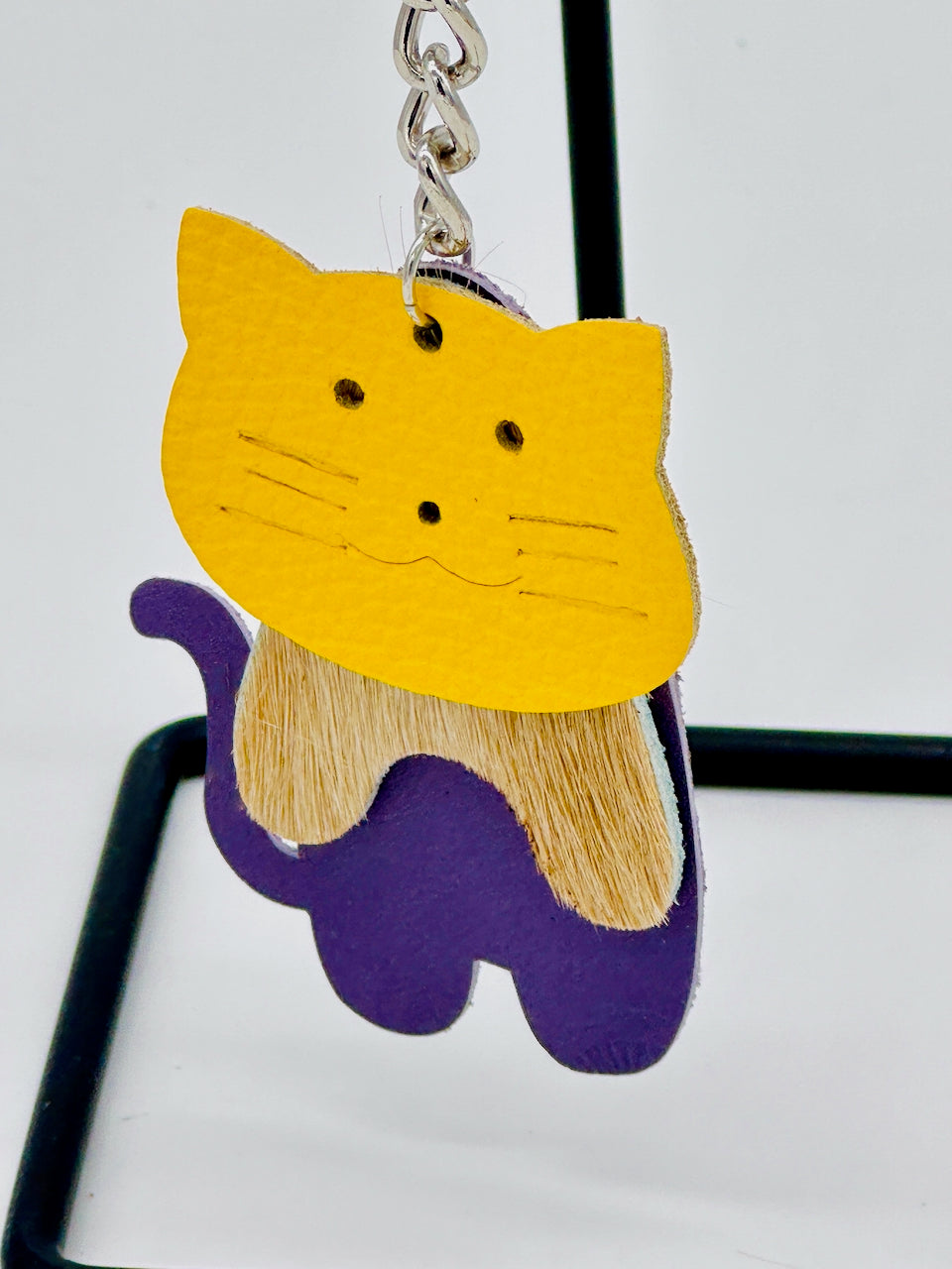 closeup of leather key chain in three parts of a cat shape