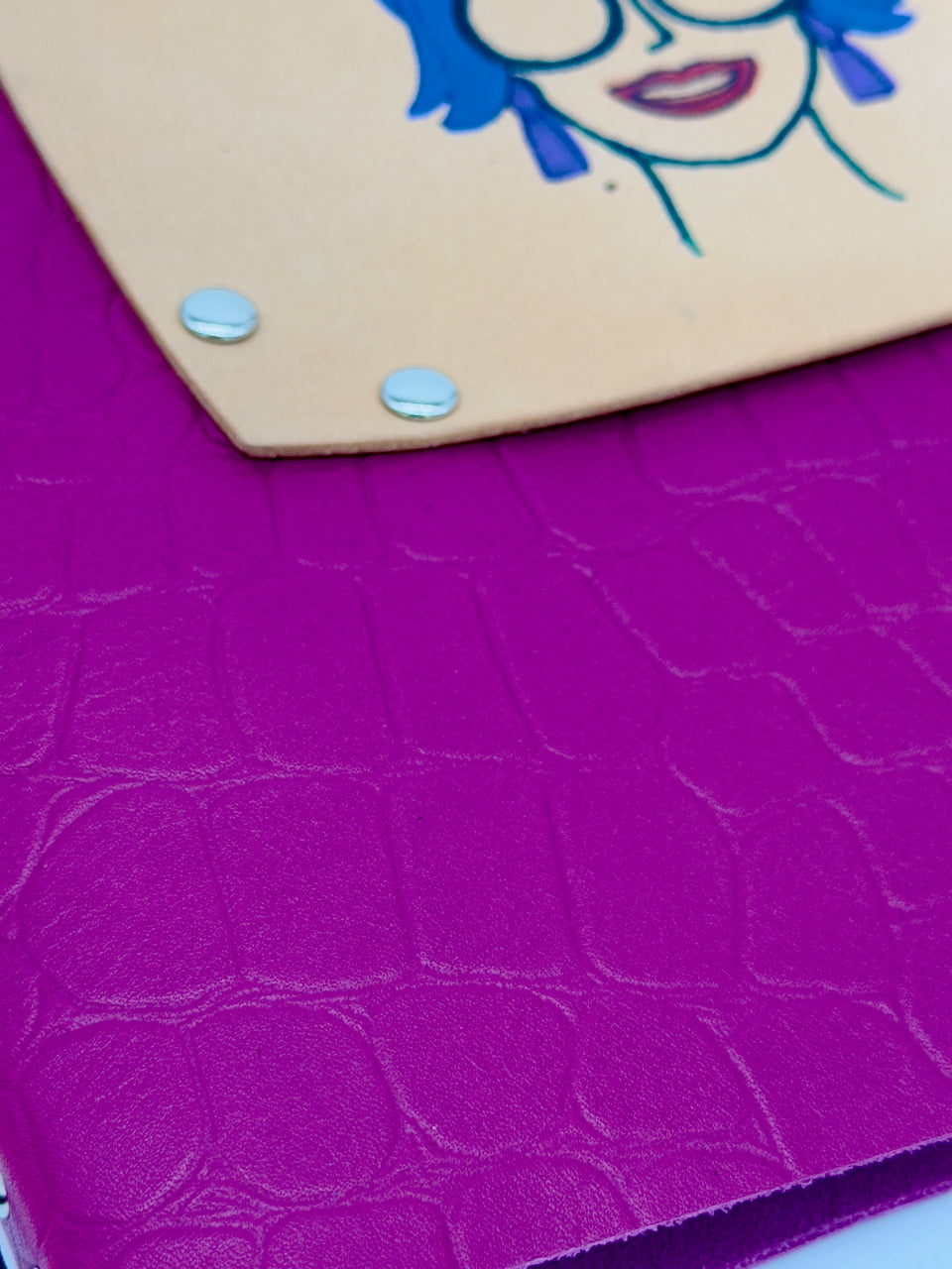 corner of leather journal with pink crocodile embossed texture