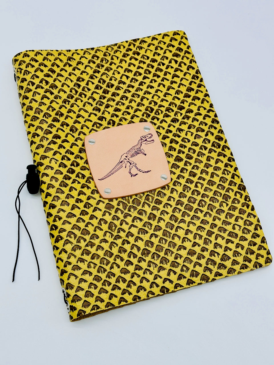 leather journal with stamped dinosaur and scaled leather