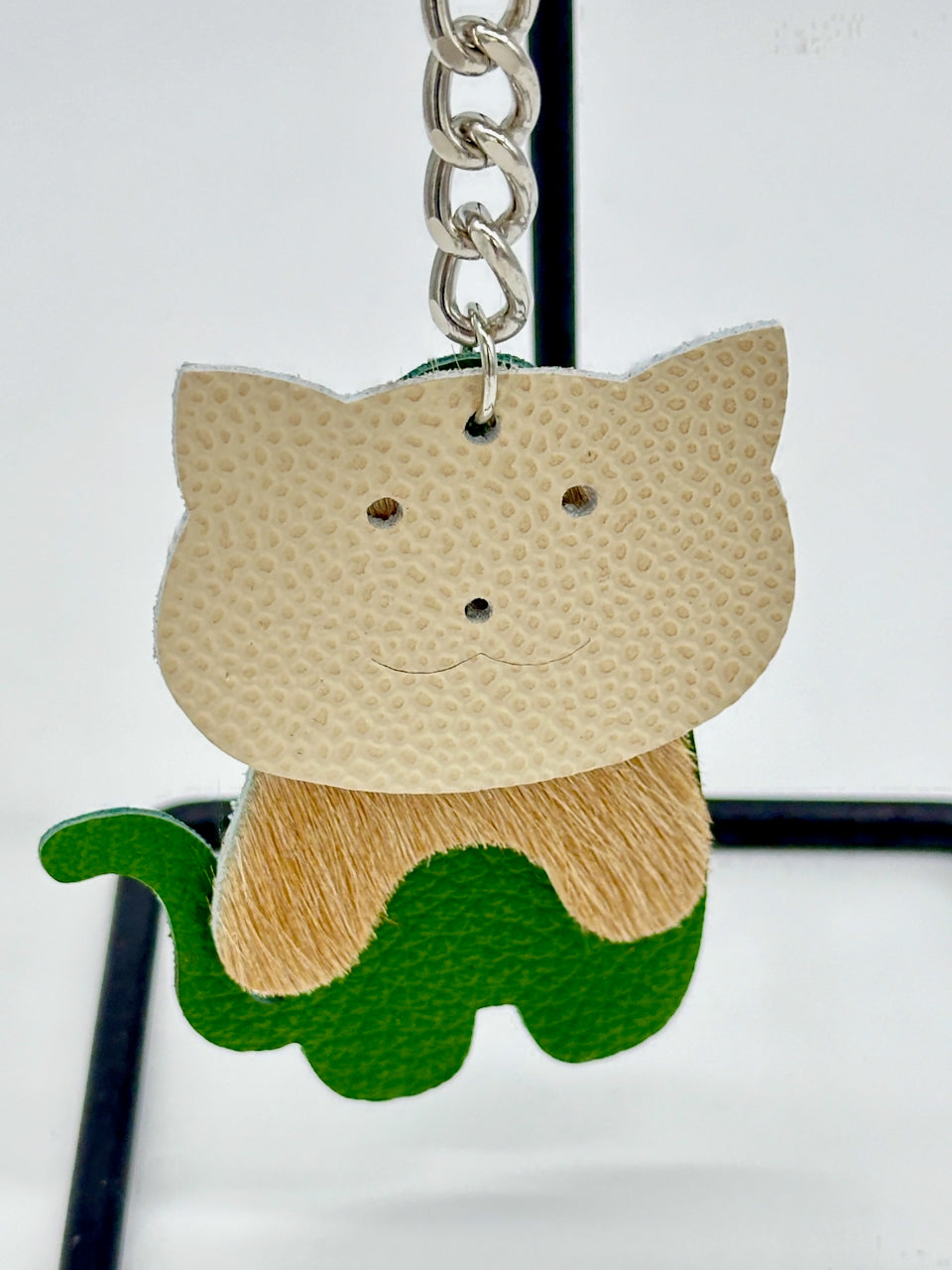 detail of cat face on leather key chain purse fob