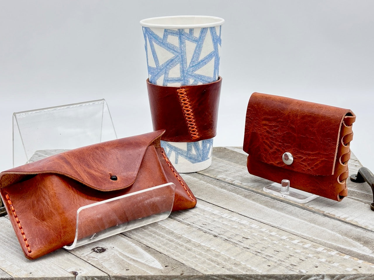 cognac brown leather glass case, coffee sleeve and wallet