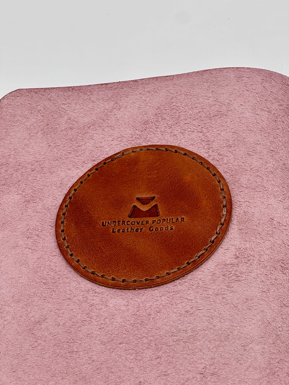 close up of embossed leather maker's mark stamp from undercover popular leather goods