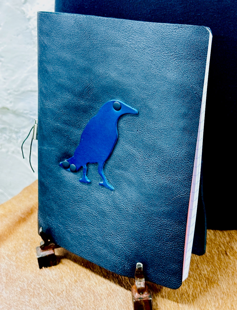 angled front cover of leather journal with raven on it