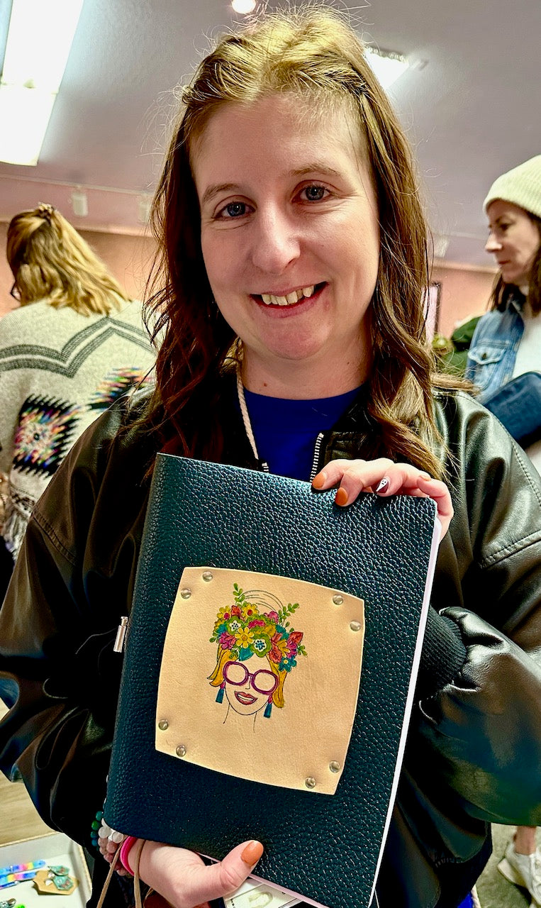 young- woman-shows-off-her-purchase-of-a-leather-journal