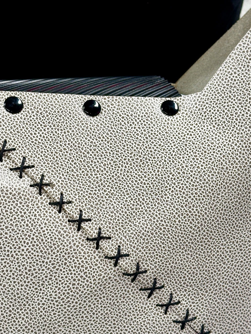 Close-up of a purse surface with black stitching details
