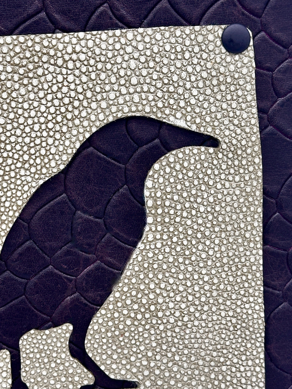 Leather journal with a textured pattern and a negative silhouette of a bird.