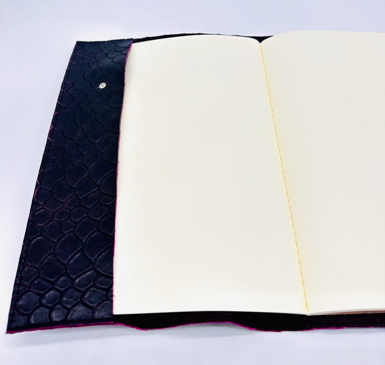 Open notebook with black textured cover on a white background