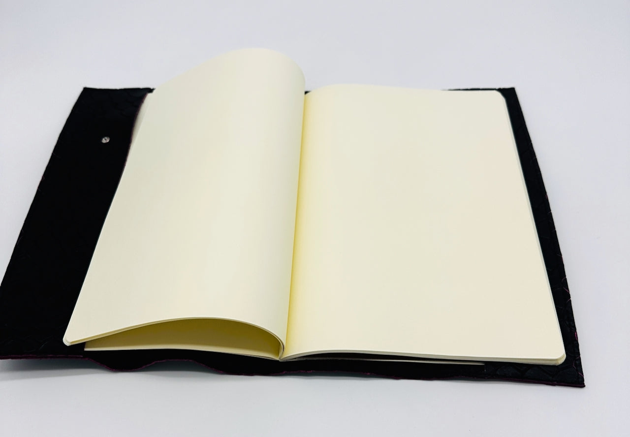 Open notebook with black leather cover on a white background