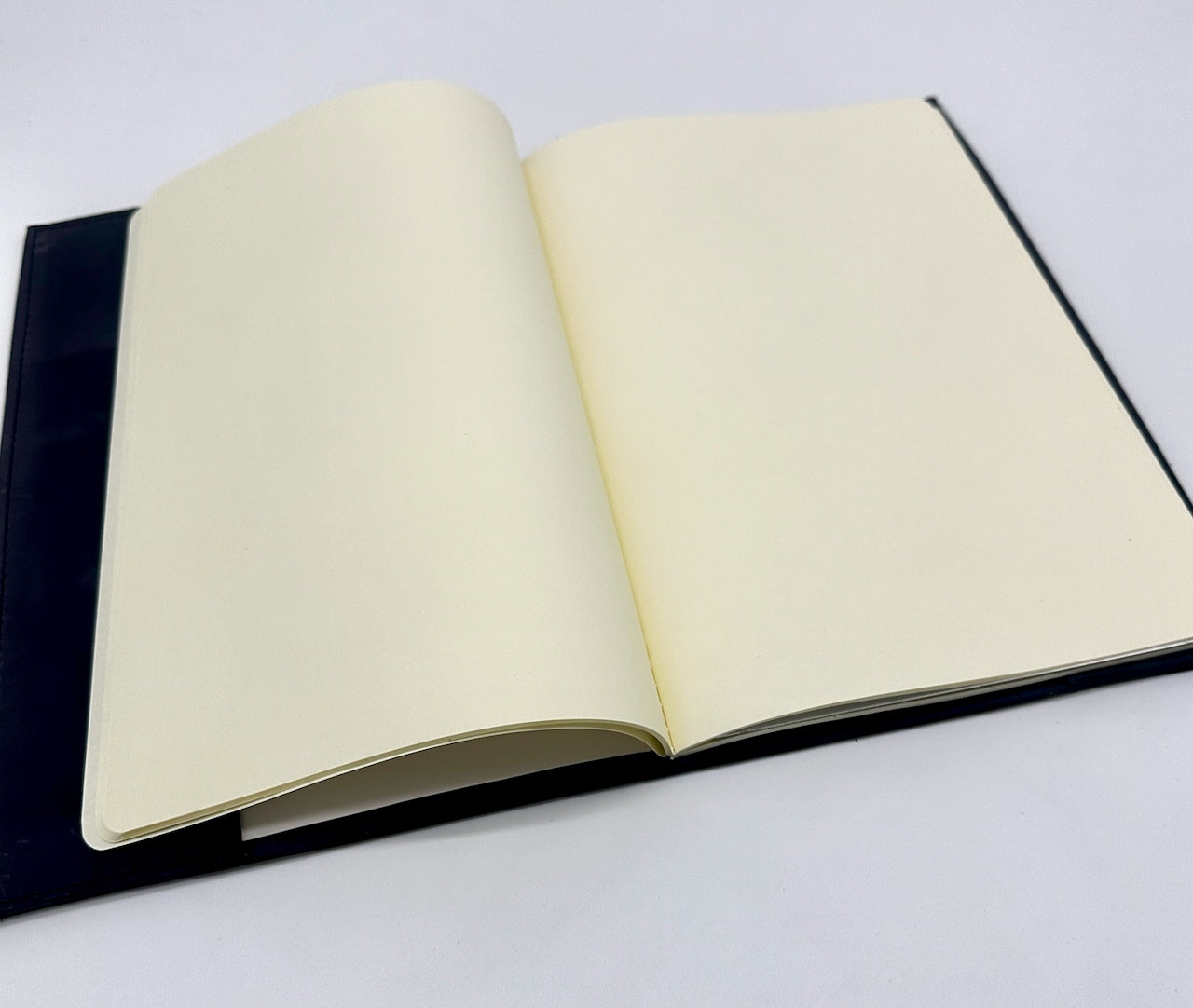 Open notebook with black cover and cream pages on a white background