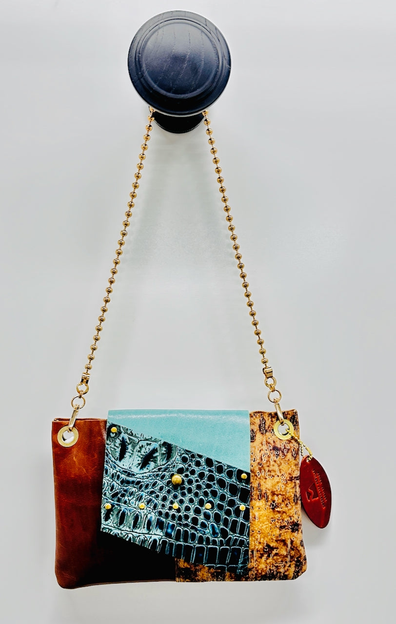 purse with gold chain with colors of teal, brown and cork