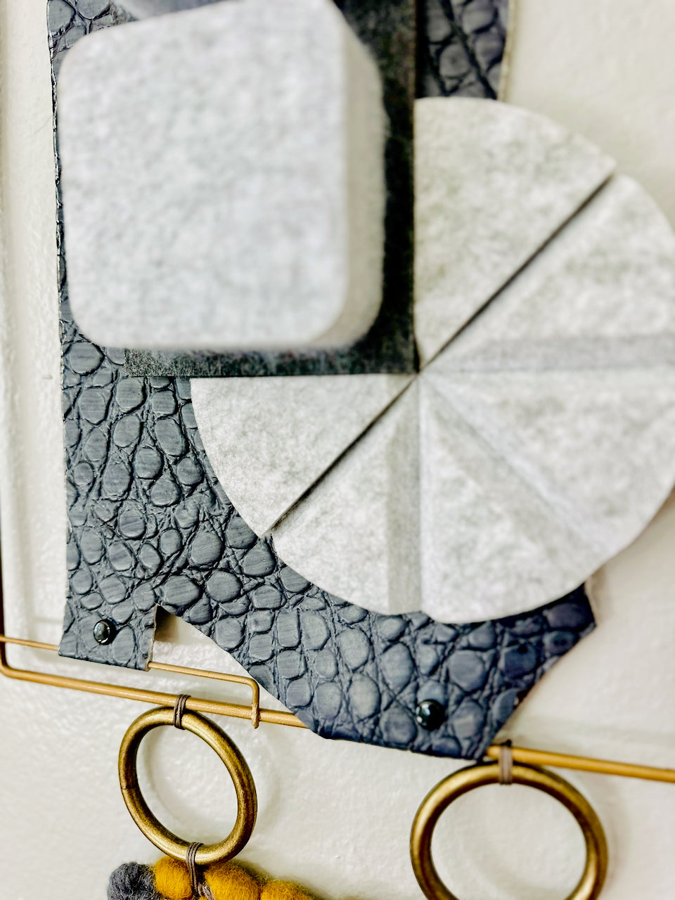Close-up of a wall art piece with geometrically shaped foam pieces on a leather background