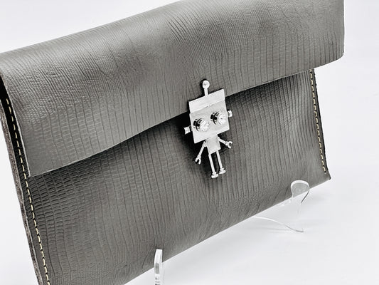 Gray textured clutch bag with a robot-shaped clasp on a white background