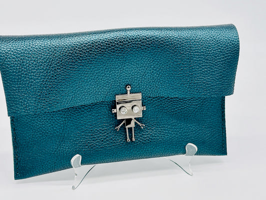 Metallic green leather clutch bag with a robot clasp on a white stand