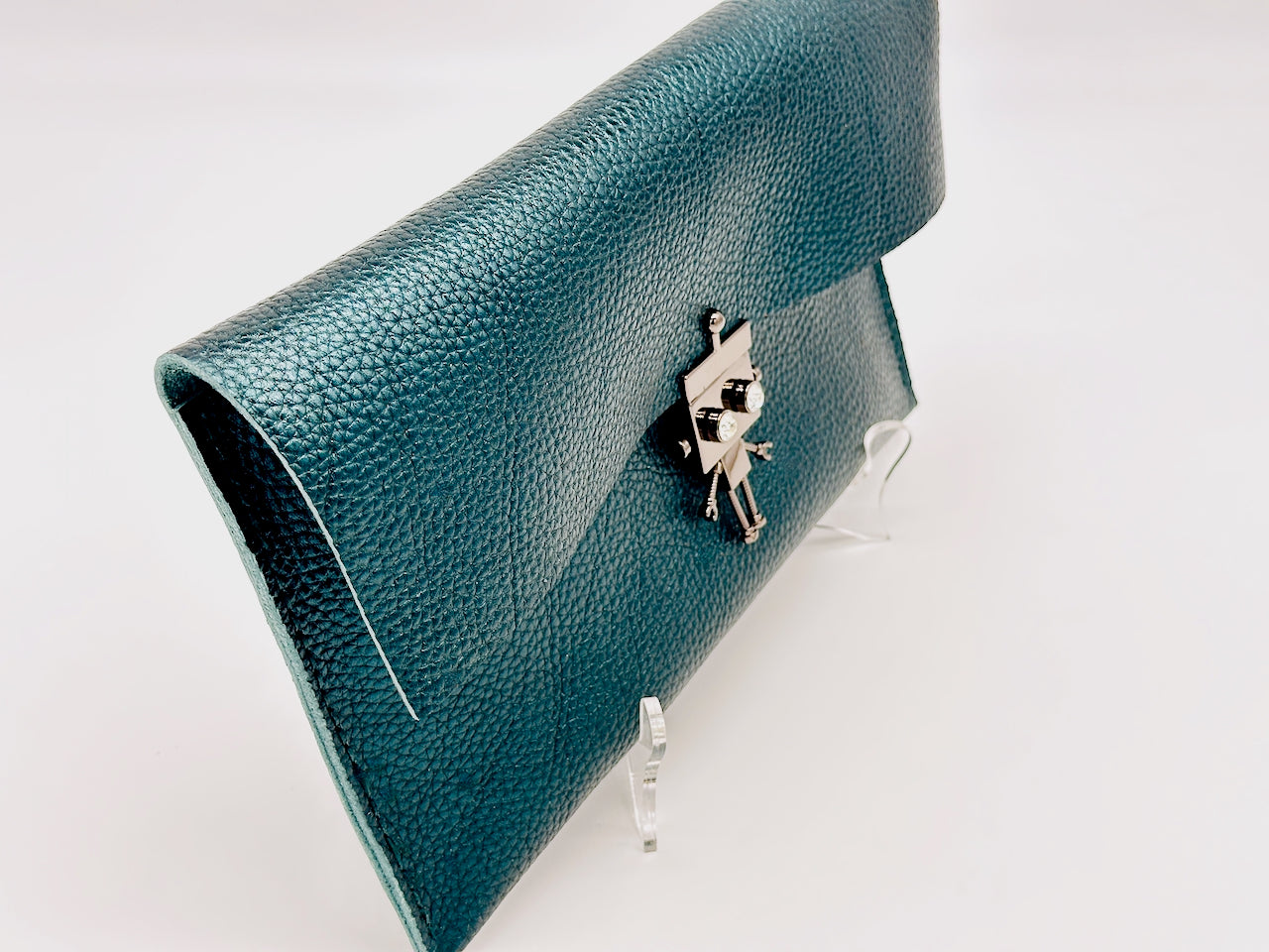 Green clutch bag with a silver robot clasp on a white background
