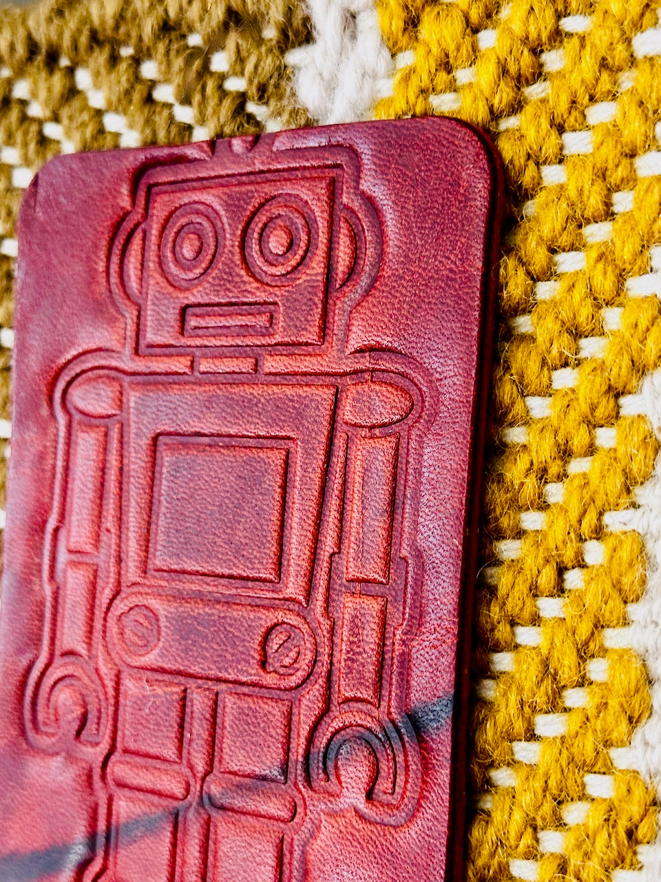 Brown leather patch with robot embossing on a textured yellow and white textile
