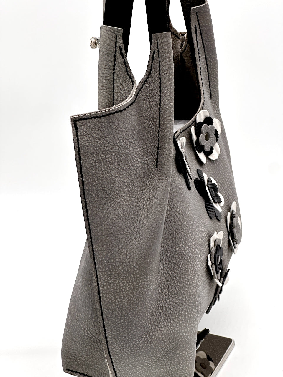 Gray handbag with floral embellishments on a white background