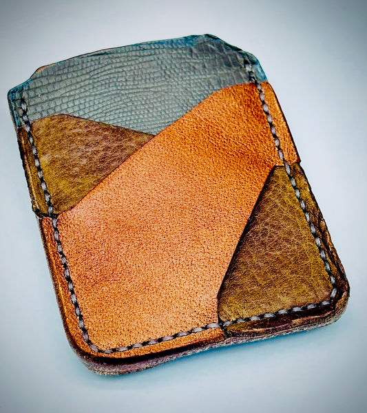 Multicolored gray, brown and cognac leather cardholder money clip on a light background