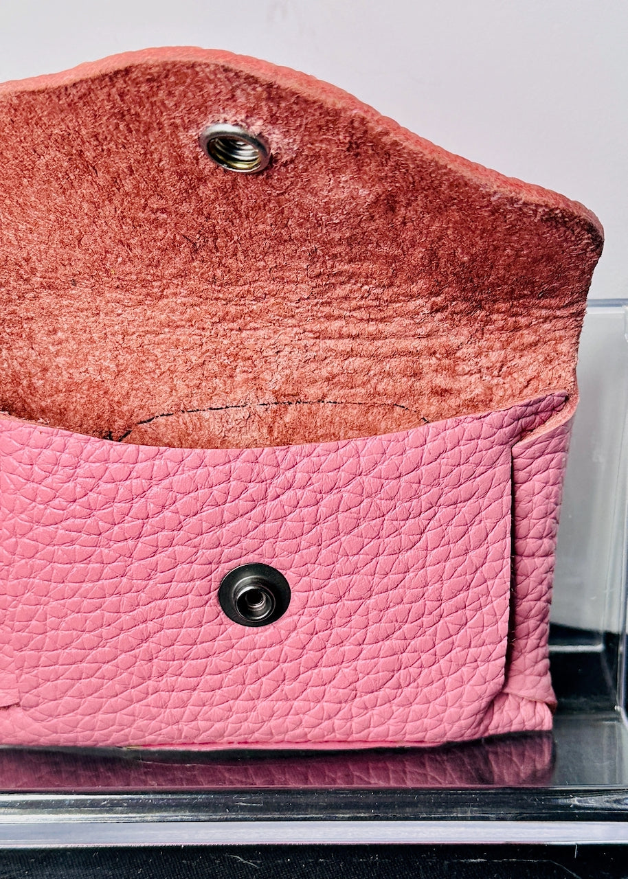 Close-up of the inside of a pink textured wallet with a snap closure