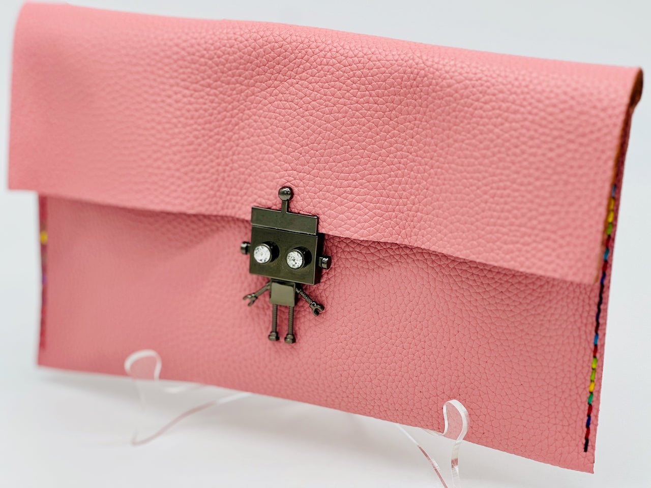 Pink clutch bag with a robot clasp lock on a white background