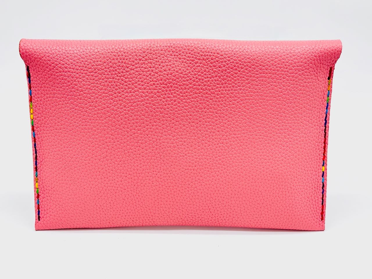back of a Pink leather clutch with colorful stitching  