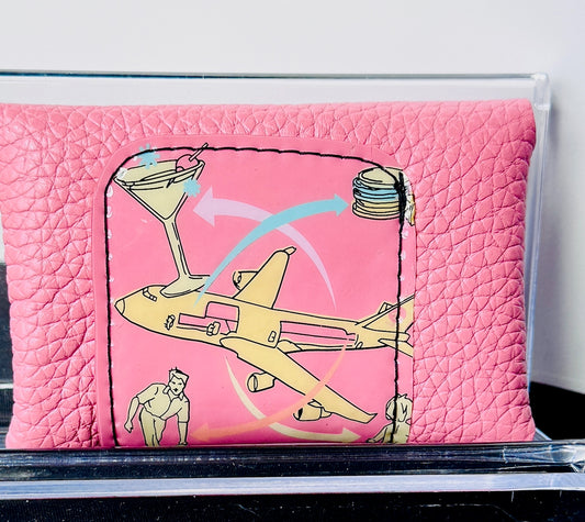 Pink wallet with airplane and cocktail design on a white background