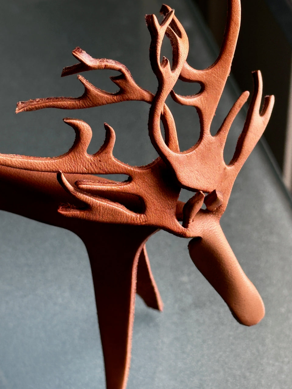 Leather reindeer figurine with antlers on a gray background