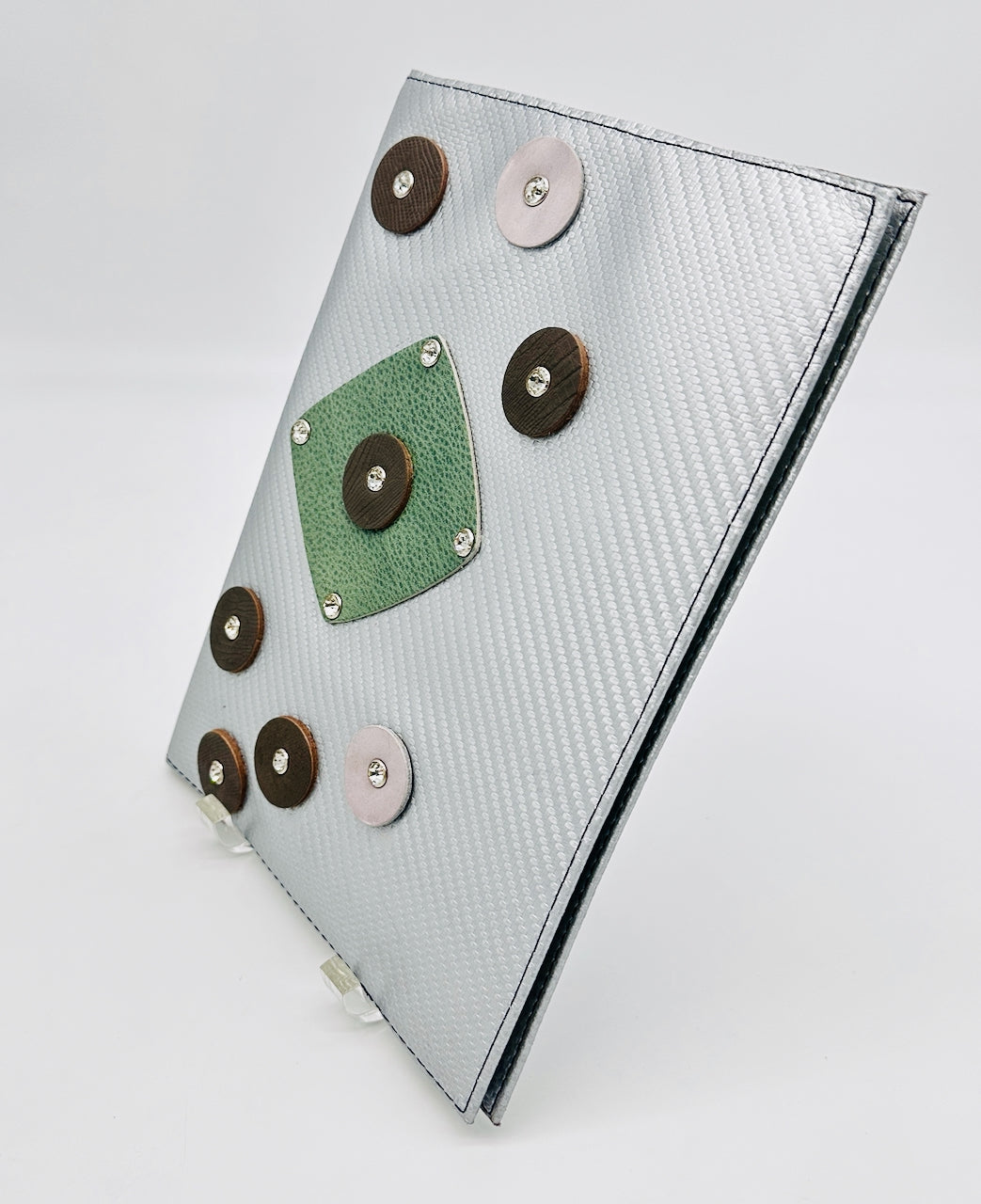 Notebook with decorative leather circles on a light gray background