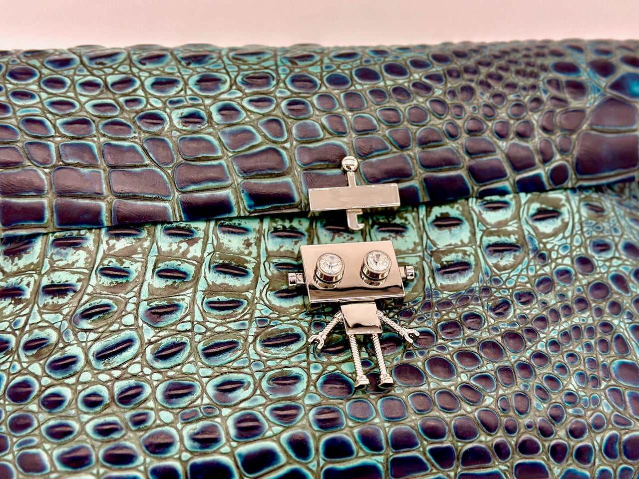 Clutch bag with crocodile texture and robot clasp unlocked 