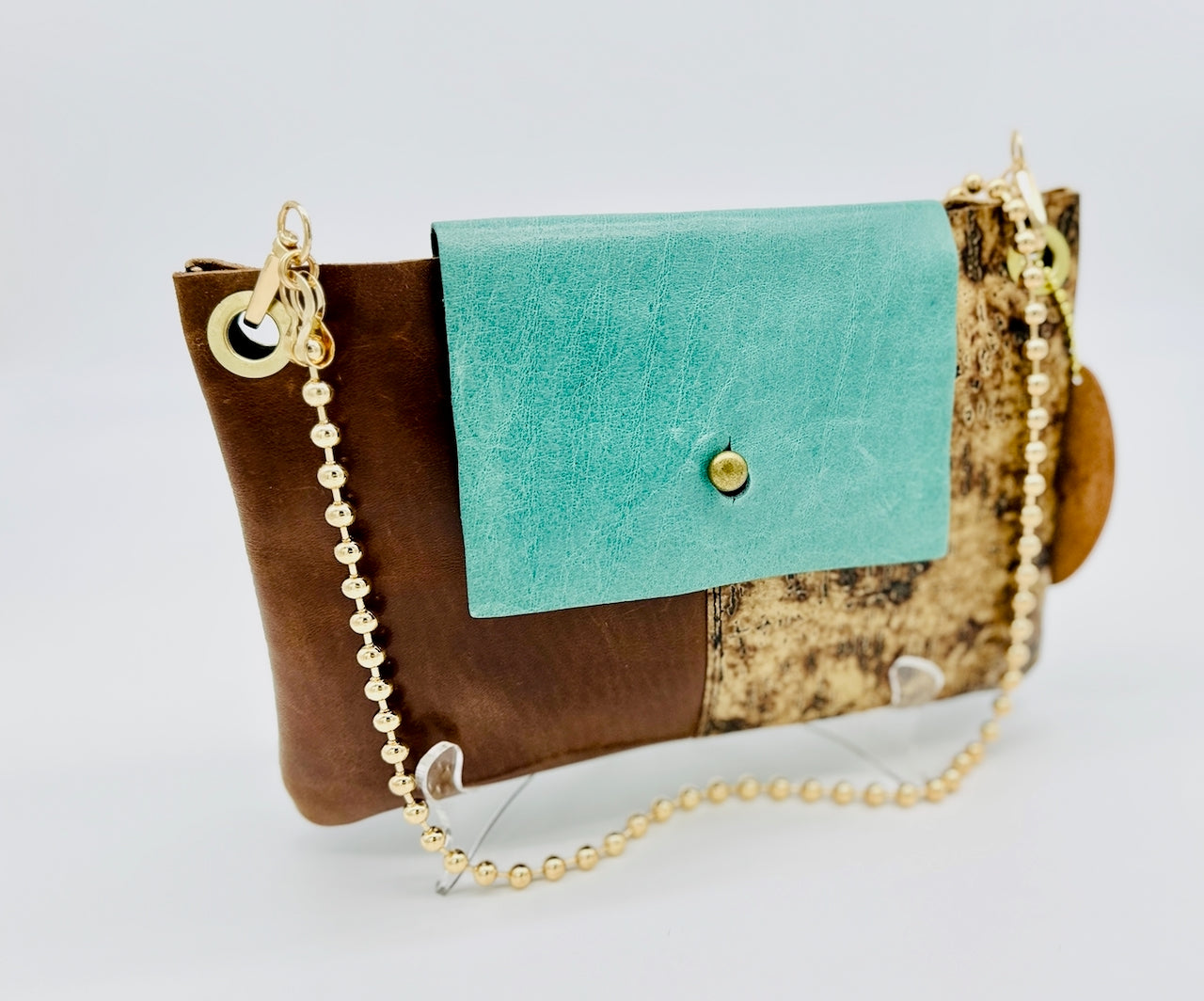 turquoise blue handmade leather purse with brown and cork leather on a white background