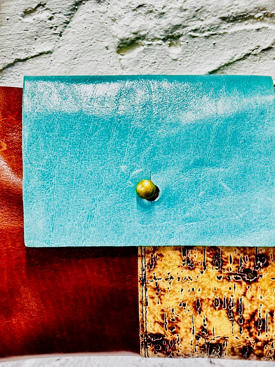 close up of blue leather flap with brass closure