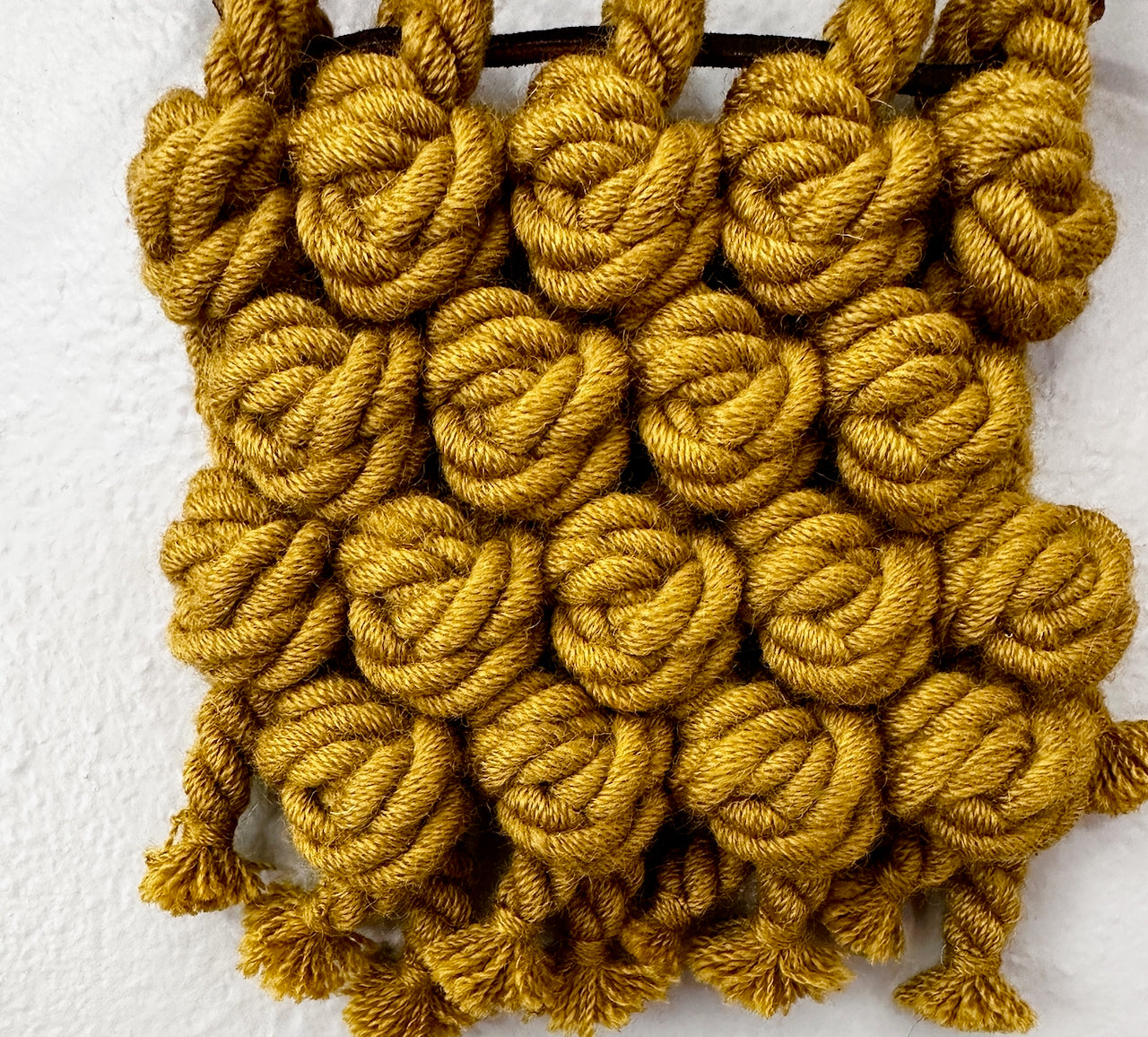 Yellow knotted yarn on a white background