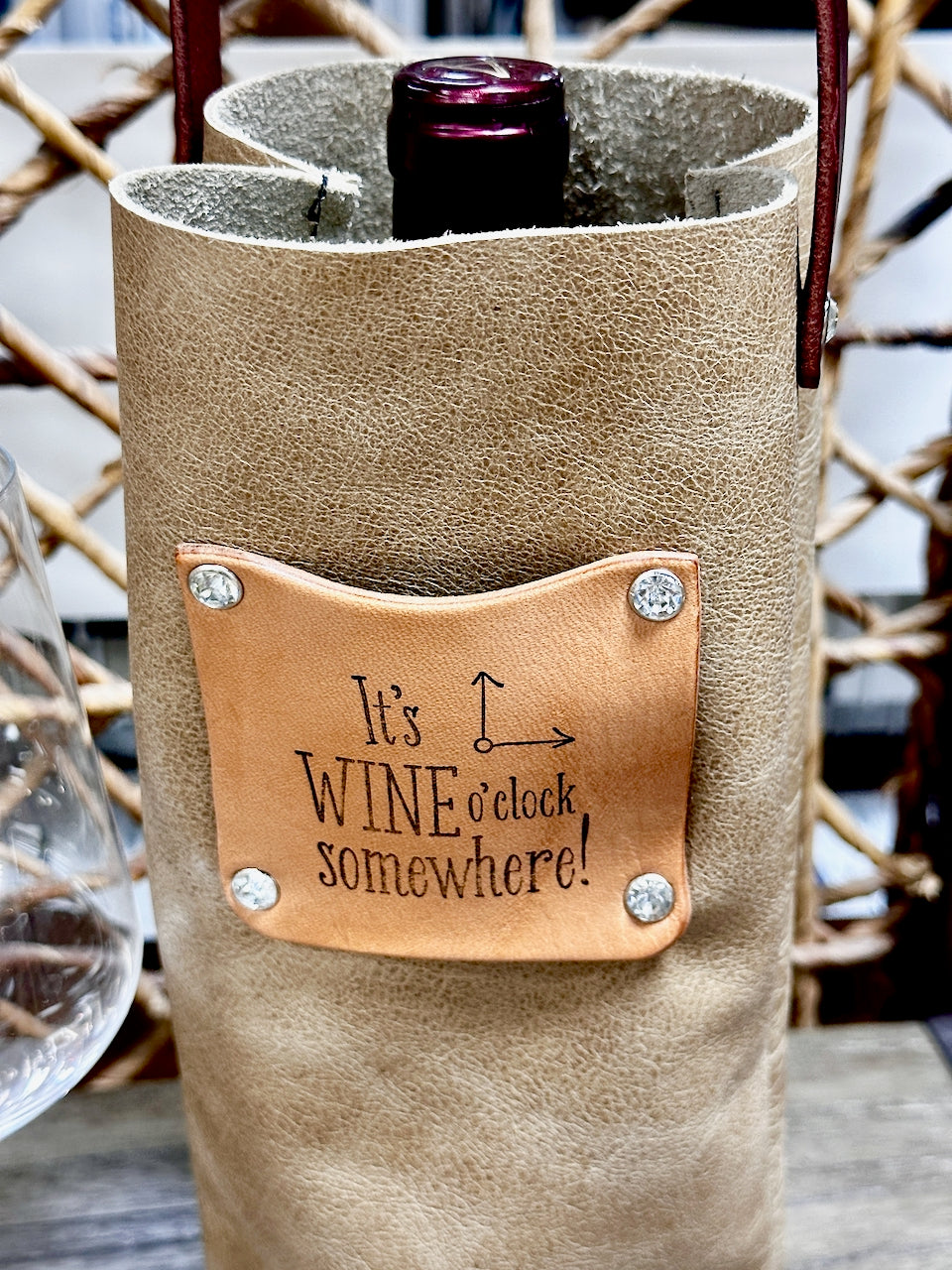 Leather patch on wine bottle carrier reads "It's wine o'clock somewhere!"