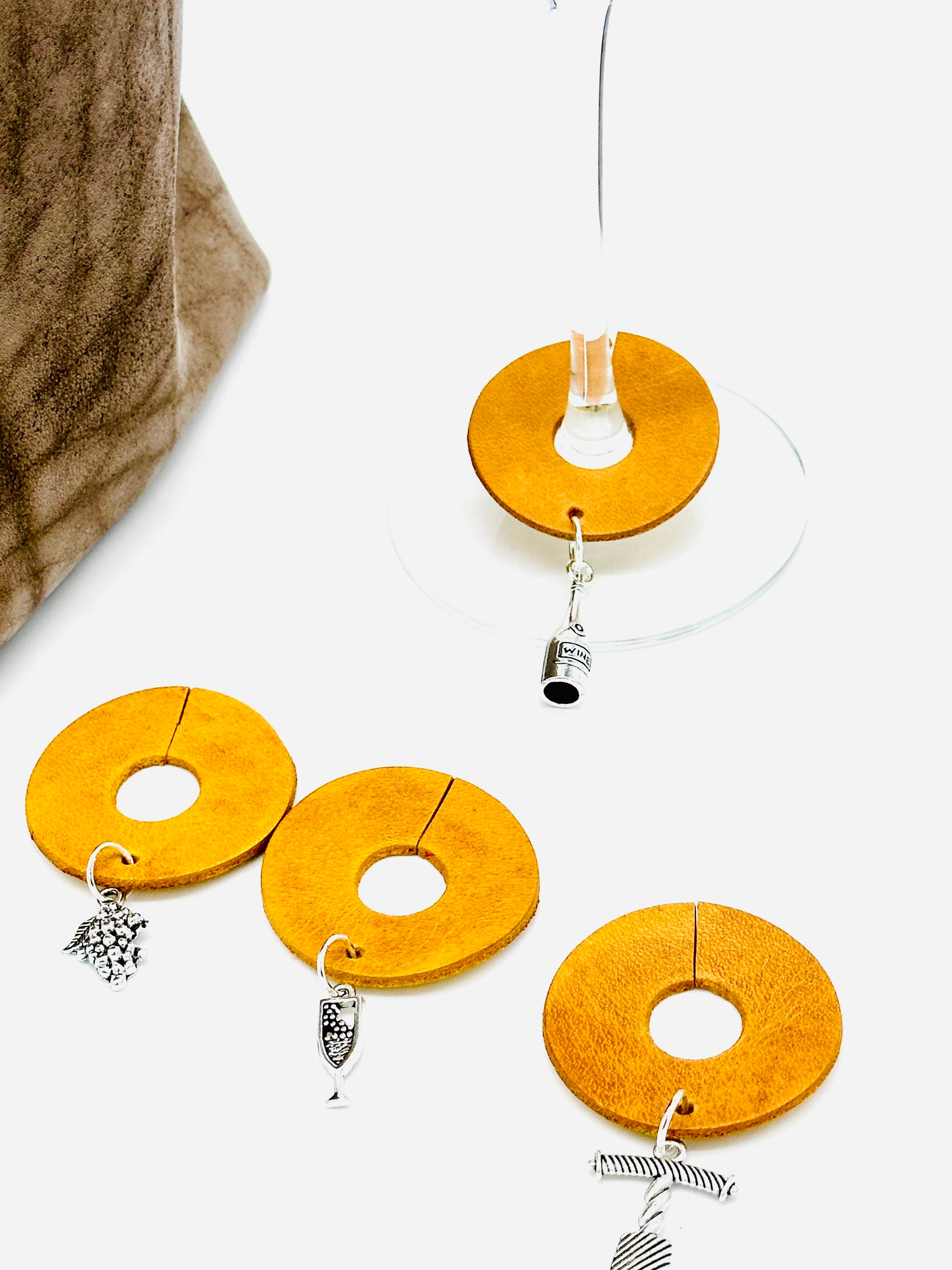 Yellow circular wine glass silver charms  on a white background