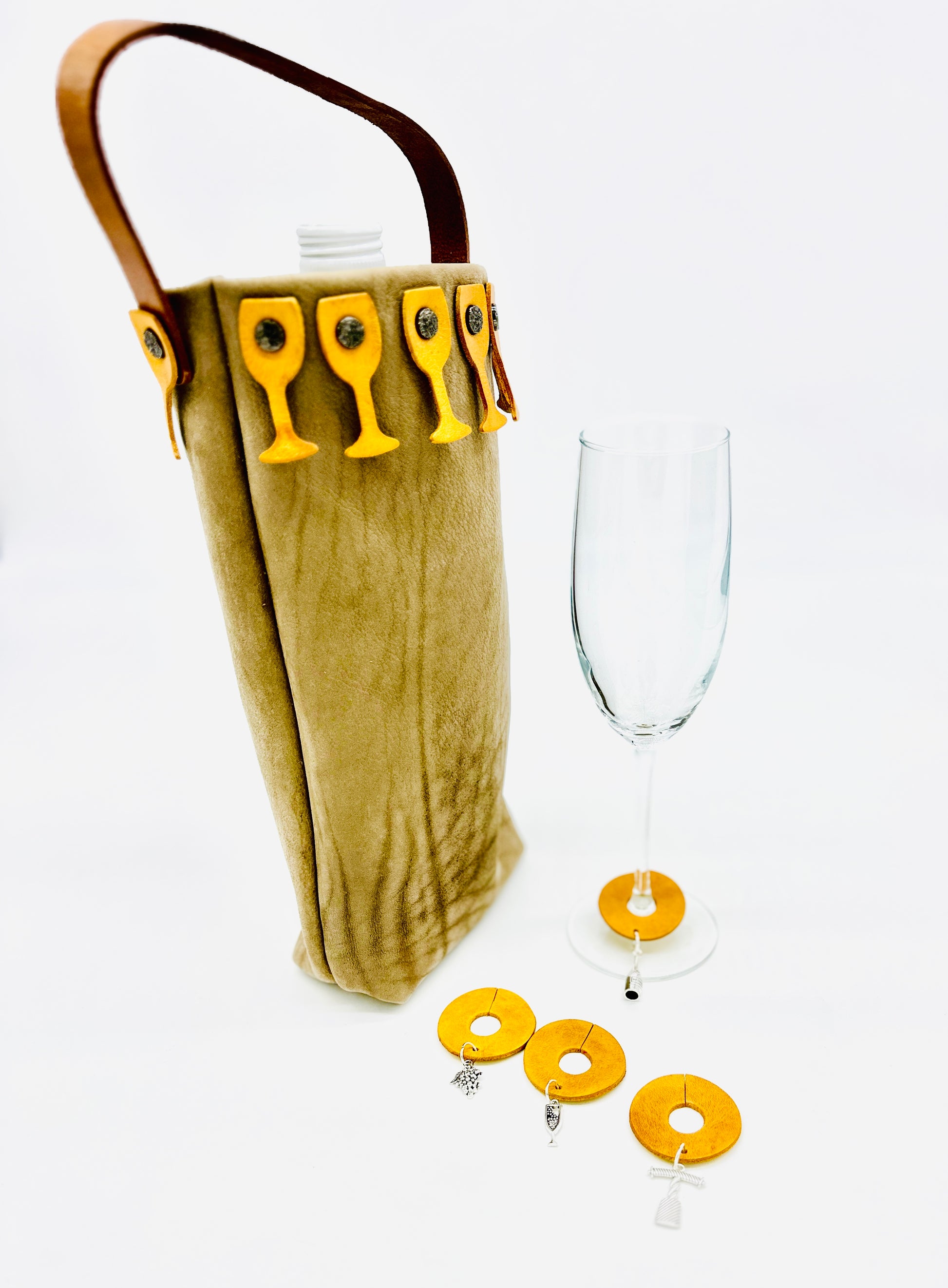 Leather Wine bottle holder with yellow wine glass charms and a clear wine glass on a white background