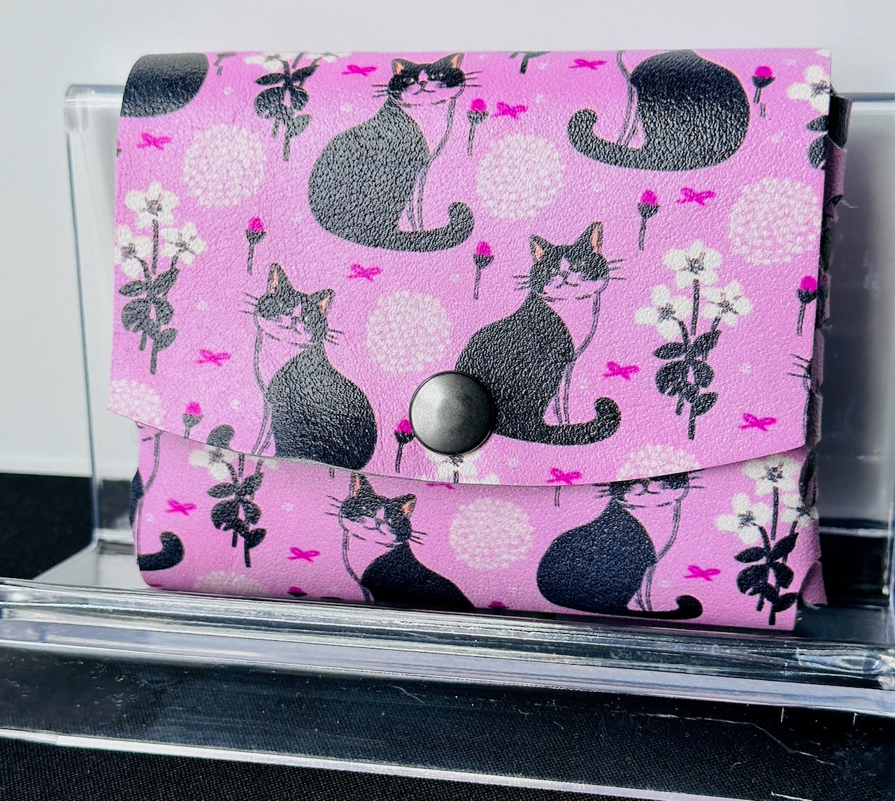 Front of pink leather wallet with black and white cats
