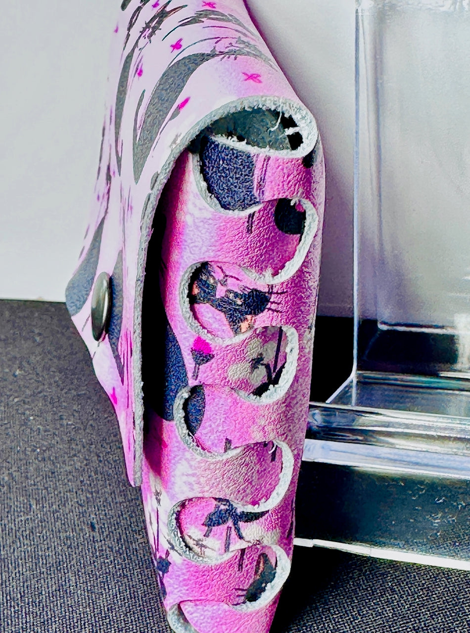 Side view of pink leather wallets with cats on it