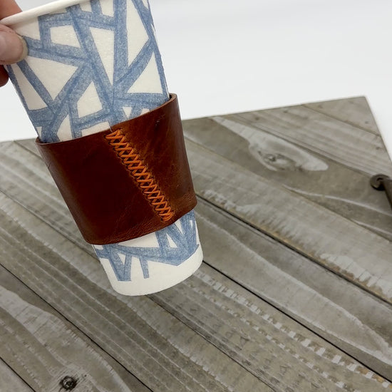 movie showing brown leather coffee sleeve