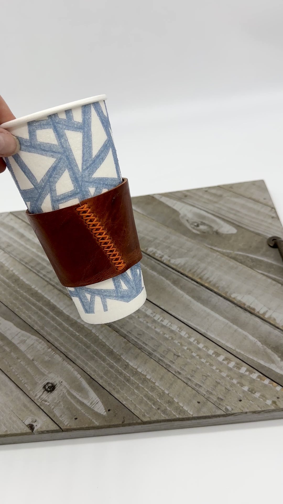 movie showing brown leather coffee sleeve