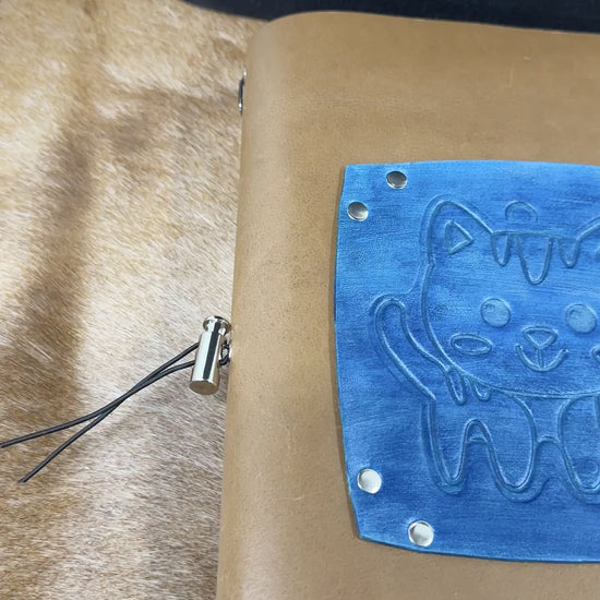 hand opens leather journal and flips through blank lined pages and turns it to the back side cover