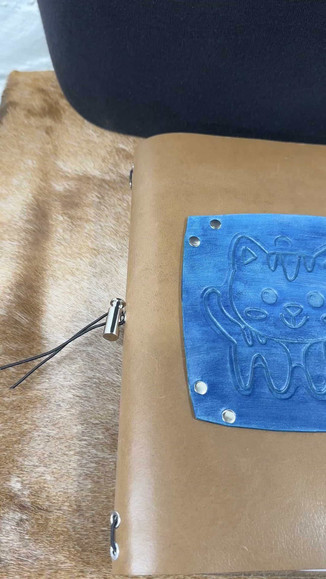 hand opens leather journal and flips through blank lined pages and turns it to the back side cover